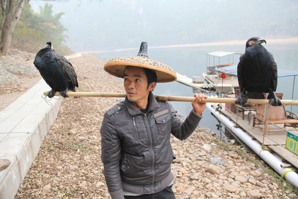 Yang Guihua, used to be a fisherman, now makes money by charging tourists to be photographed with his two cormorants. River protection rules cut into incomes