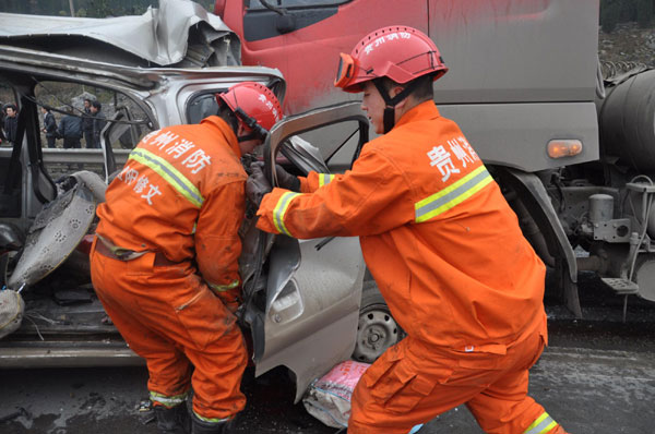 Firefighters examin the wreck of a minibus after it collided with a truck on a highway in Guizhou, Feb 9, 2012. 7 killed in traffic accident in SW China