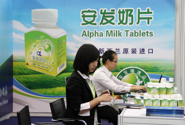 Workers arrange milk products imported from New Zealand at a dairy expo in Beijing. Chemical residue in NZ milk raises concerns