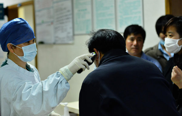 A doctor examines a patient at a fever clinic at the No 1 Hospital of Zhejiang University in Hangzhou. Long Wei / Xinhua Avian flu quiets song in bird market