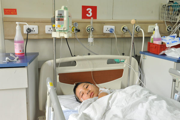 Teng Dejin, a 13-year-old boy from Yunnan province, in an intensive care unit at the Shanghai Children's Hospital on Wednesday. Yang Xiaodong / for China Daily Boy clings to life after father's abusive attack