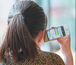 A woman in Shanghai uses WeChat on her smartphone. Users may soon be charged for the service, which is currently free. Provided to China Daily Latest technology gets people talking