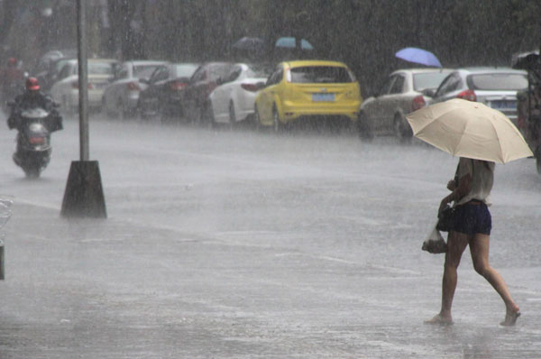 Local residents cope with heavy rainfall as water covered the streets in Shantou, South China’s Guangdong province on May 19, 2013. China issues rainstorm alert for southern region