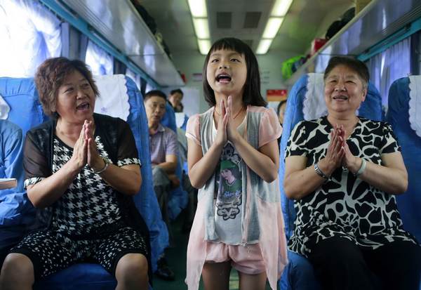 Xiang Jinyue, 7, sings as she travels with her grandparents on the Kunming-Mengzi train. Photo by Feng Yongbin / China Daily Tunnel builders sweat it out on new rail line