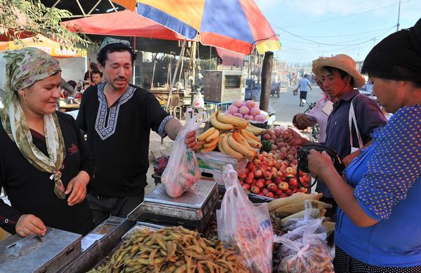 Abudurehman Wusman, second left, reopens his fruit stall in Lukqun town, Shanshan county in the Xinjiang Uygur autonomous region, after the June 26 attack. Zhen Shixin / for China Daily Pain lingers after Xinjiang terrorist attack