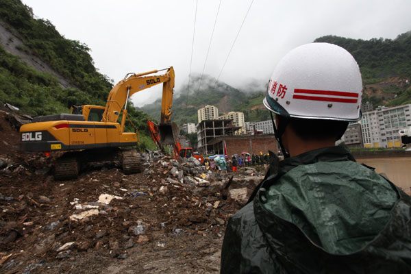Rescuers rescue people buried underneath after a landslide in a village in Zhaotong city, Southwest China's Yunnan province, on July 6, 2013. 5 dead, 4 injured in SW China landslide
