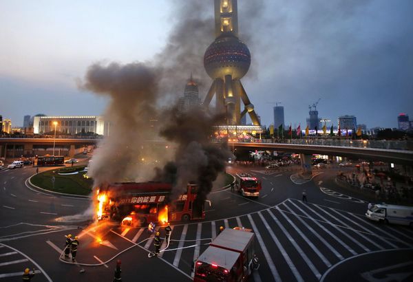 double-decker tourism bus is seen on fire in from of the Oriental Pearl Tower in the Pudong financial district of Shanghai July 8, 2013. Double-decker bus caught fire in Shanghai