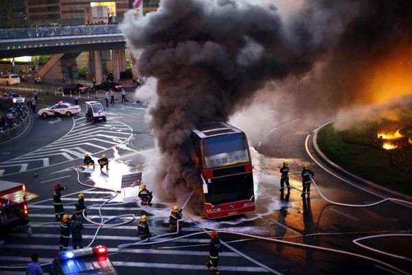 double-decker tourism bus is seen on fire in from of the Oriental Pearl Tower in the Pudong financial district of Shanghai July 8, 2013. Double-decker bus caught fire in Shanghai