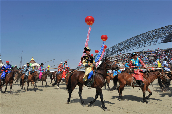 A squad of horseracing jockeys trot into the opening ceremony of the 24th Tourism Naadam Festival Naadam Festival trots into town for wild games