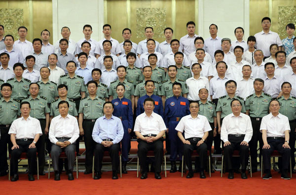 China's top leaders Xi Jinping (C front), Li Keqiang (3rd R front), Zhang Dejiang (3rd L front), Yu Zhengsheng (2nd R front), Liu Yunshan (2nd L front), Wang Qishan (1st R front) and Zhang Gaoli (1st L front) meet with astronauts and scientists who participated in the Shenzhou-X mission, at the Great Hall of the People in Beijing, July 26, 2013. President Xi meets Shenzhou X astronauts