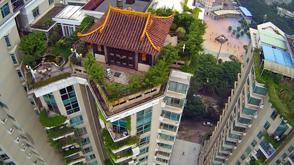 Netizens said the temple-shaped villa on top of a 19-story apartment building in Shenzhen is the 'most impressive' illegally constructed rooftop building to be exposed online. Lu Li / for China Daily Officials investigate villa in shape of temple