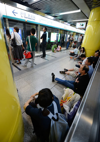 Passengers wait at the Xuanwumen Station of the suspended Beijing Subway Line 4, Sept 16, 2013. Beijing's No 4 subway line suspended due to signal failure