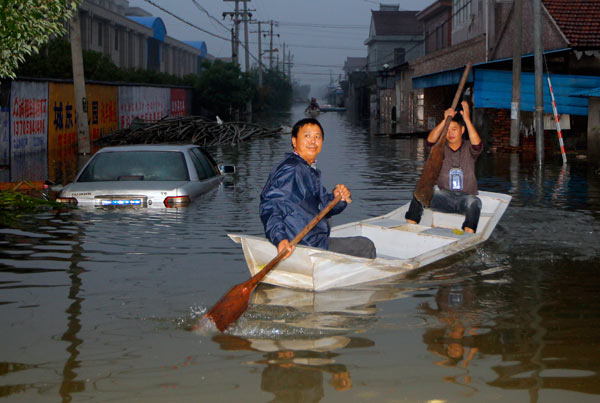 A boat proves to be better than any car as storms cripple Yuyao, an industrial city in Zhejiang province, on Wednesday. Gao Erqiang / China Daily Floodwaters hamper relief efforts