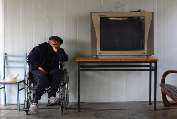A man sleeps on a wheelchair next to a television set at a nursing home on the Double Ninth Festival, or Chongyang Festival, in Kunming, Southwest China's Yunnan province, Oct 13, 2013. The Chinese honour their elderly during the festival, which falls on the 9th day of the 9th month in the Chinese lunar calendar. China embraces first Seniors' Day