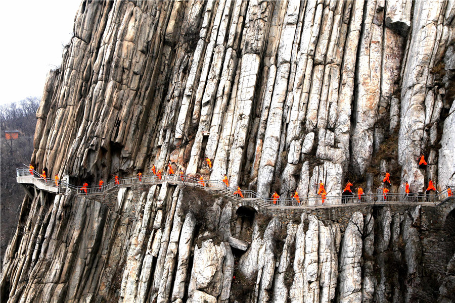 Martial artists practice Shaolin kung fu on cliff