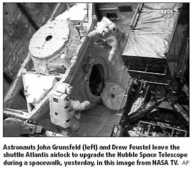 Astronauts leave shuttle to work on Hubble
