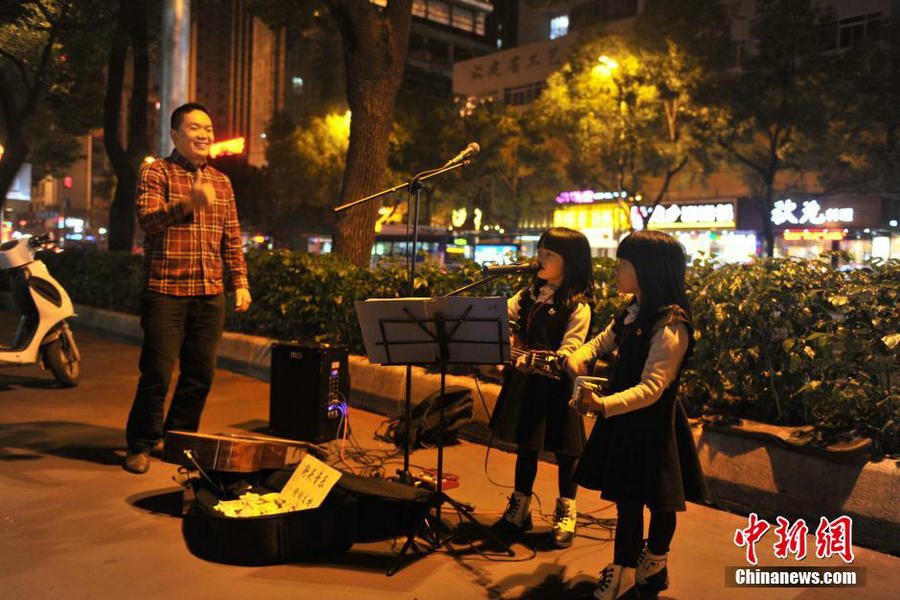 Six-year-old twin street musicians tour with their father