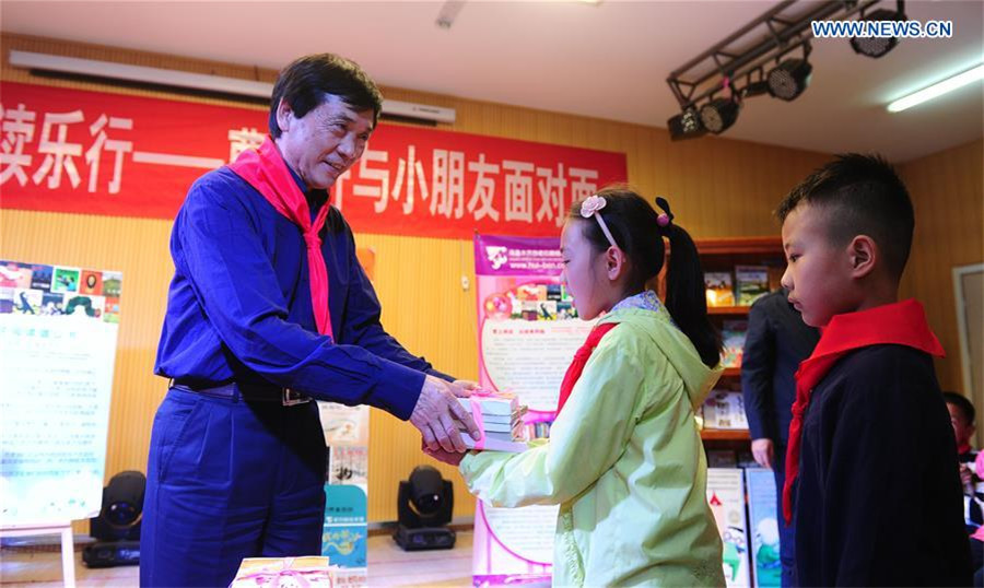 Cao Wenxuan presents books to children, Northwest China's Xinjiang