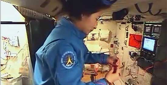 劉洋在“天宮”內(nèi)用紅絲繩編織中國結(jié)