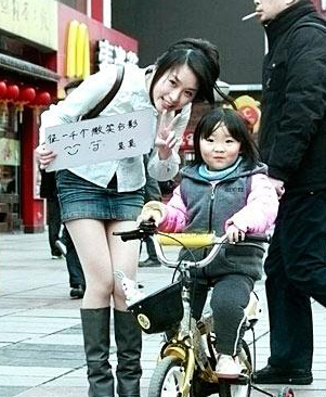 美女在南京街頭舉牌征集1000個微笑合影