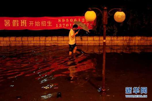 北京夜降暴雨 積水中勇現(xiàn)“淡定哥”(組圖)