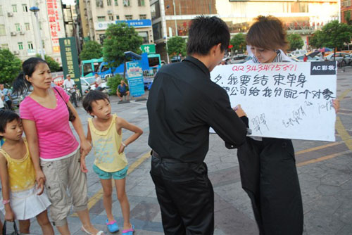 女職員當街舉牌要公司分配對象 遭公司罰款(圖)