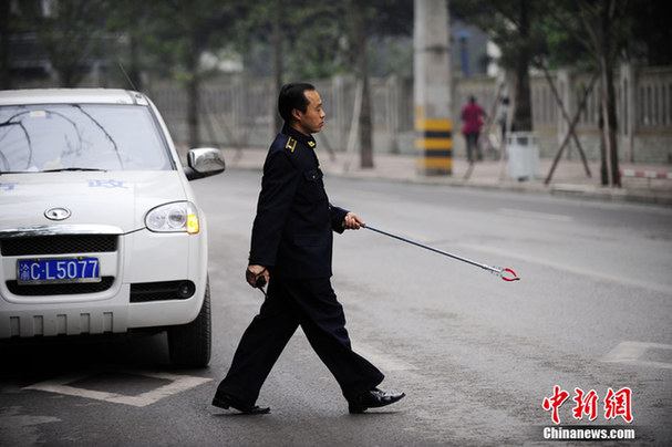 重慶城管佩帶蛋糕夾上街拾垃圾
