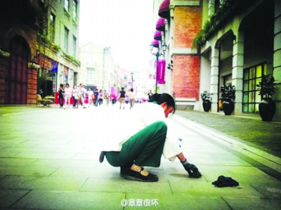 清潔工蹲地鏟口香糖照片走紅 網友呼吁尊重勞動(圖)