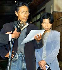 Masumi Koda, father of Shosei Koda, identified as the Japanese man taken hostage and threatened to be beheaded by al-Qaeda-linked militants in Iraq, speaks to reporters with his weeping wife Setsuko outside their home in Nogata, southern Japan October 27, 2004. Japanese Prime Minister Junichiro Koizumi insisted that Japan would not withdraw its troops from Iraq despite a threat to behead the hostage unless Tokyo pulled them out.