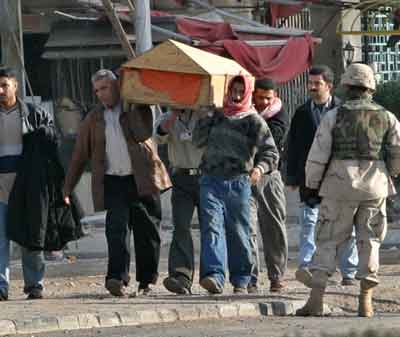 U.S. Army soldiers watch as Iraqi men carry the coffin of a friend killed in a suicide car bomb attack near the Australian embassy in Baghdad January 19, 2005. Suicide car bombers attacked the Australian embassy and a police headquarters in Baghdad on Wednesday, killing at least seven people in the latest deadly guerrilla strikes before Iraq's January 30 elections. [Reuters]