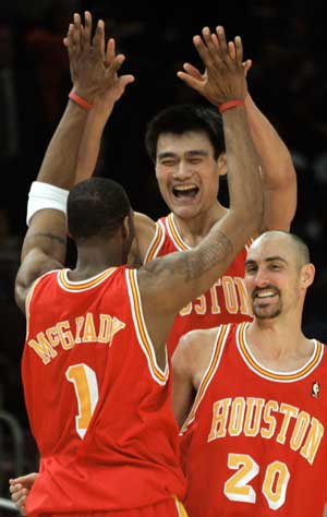 Houston Rockets center Yao Ming, guard Tracy McGrady (1) and guard Jon Barry (20) celebrate after forward Scott Padgett made a last second shot to beat the New York Knicks 92-91 in their NBA game in New York's Madison Square Garden, January 21, 2005.