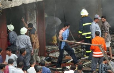 Iraqis rush to the scene to extinguish a fire after a car bomb exploded near a market in eastern Baghdad, Iraq, Thursday, May 12, 2005, killing at least six people and wounding 13, police said.(AP