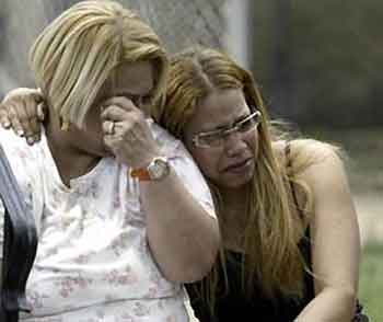 Two unidentified women react after arriving on the scene of a rowhouse fire in the Kensington section of Philadelphia, Sunday, June 12, 2005.