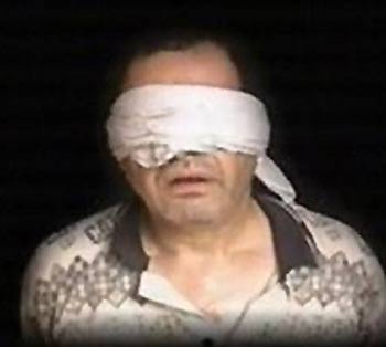 A blindfolded man purported to be Ihab al-Sherif, head of the Egyptian Diplomatic Mission in Iraq, is seen in a video on an al-Qaida-linked Web site released Thursday July 7, 2005 at an unknown location in Iraq.