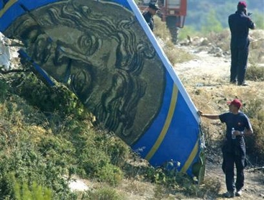 A firefighter pauses to look at the wreckage of the Cypriot Helios plane on the third day of the investigations into the three missing bodies. The crash Sunday on a hillside in Grammatiko, 40 kilometers north of Athens, Greece killed all 121 passengers on board. (AP