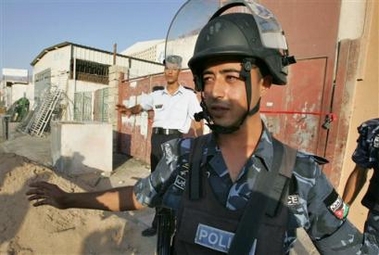 Jordanian policemen stand guard near a warehouse in Jordan's port town of Aqaba, from where attackers fired three Katyusha rockets early Friday, Aug. 19, 2005, killing a Jordanian soldier. 