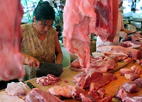 A vendor prepares pork at a market in Shanghai yesterday. China錕絪 far south is on high alert since one person was killed and three infected by a pig-borne disease that had left nearly 40 dead in the southwest. The latest person killed by the disease, caused by the Streptococcus suis bacterium, had handled infected pork, Xinhua news agency said on Tuesday. The three other victims, all butchers, also likely had contact with infected meat.