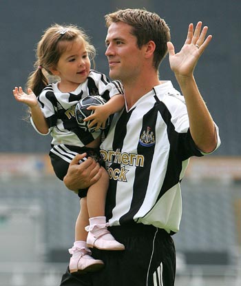 England striker Michael Owen walks across the pitch with his daughter Gemma Rose, wearing a Newcastle United shirt, after his signing by the club at St James' Park in Newcastle August 31, 2005. Owen joins Newcastle United from Spain's Real Madrid.