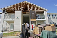 Residents at 1315 19th St in Gulfport, Miss., move their belongings out of the apartment building on Wednesday, Sept. 7, 2005. Jaylen Moore left his great-grandmother Jane Carroll's apartment in this building to live in Chicago after Hurricane Katrina damaged their home. (AP 