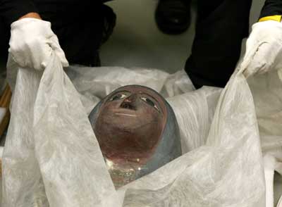 A worker wraps up the casket of a 2,500 year-old mummy after scientists scanned the body to learn more about its history at the Centre Hospitalier Universitaire of Liege in eastern Belgium, September 12, 2005. Scientists are using the same technology that showed the world Tutankhamen's face earlier this year to try to verify the identity of the mummy.