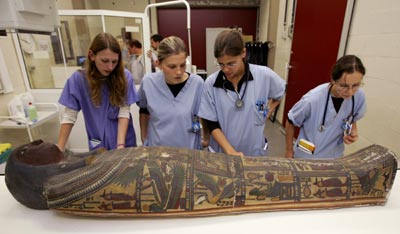 Belgian students inspect the casket of a 2,500 year-old mummy before scientists scan the body to learn more about its history at the Centre Hospitalier Universitaire of Liege in eastern Belgium, September 12, 2005. Scientists are using the same technology that showed the world Tutankhamen's face earlier this year to try to verify the identity of the mummy.
