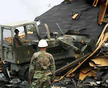 A heavy machinery removes debris from a destroyed house on a street of ninth area in New Orleans September 18, 2005. [Reuters]