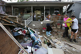Yasmin Abbyad (R), 18, points to debris as Sarah Dunn (L), 17, and Kaitlyn Lombardo, 17, carry personal belongings from Lombardo's flood damaged home, on the second day since residents of the "Uptown" neighborhood were allowed to visit and stay in their homes, in New Orleans October 1, 2005.