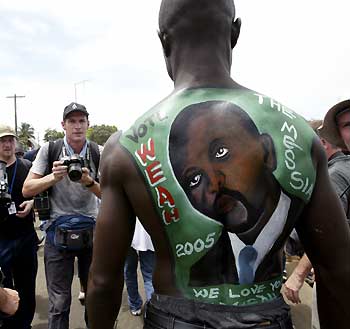 A man with a portrait of Congress of Democratic Change (CDC) candidate in Liberia's presidential elections George Weah painted on his back poses for a photographer in Monrovia October 8, 2005. Tens of thousands of supporters of the Liberian presidential hopeful brought Monrovia to a standstill on Saturday as the millionaire soccer star held a final campaign rally before Liberia's first post-war elections.