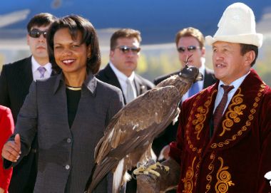 U.S. Secretary of State Condoleezza Rice (L) stands next to a Kyrgyz falconeer during a visit to Bishkek October 11, 2005. Rice arrived in Kyrgyzstan on the first leg of her Central Asia tour.