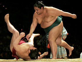 Japanese sumo wrestler Takekaze (L) is thrown out of the ring by Miyabiyama, also of Japan, in the second round during the final day of the Grand Sumo Las Vegas tournament at the Mandalay Bay Events Center in Las Vegas, Nevada October 9, 2005. Miyabiyama later lost to Asashoryu in the semi-finals.