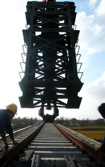 Chinese workers lay a railway in Pudong, Shanghai, October 20, 2005. China's economy expanded a faster-than-expected 9.4 percent in the third quarter from a year earlier and is showing little sign of cooling amid strong industrial output and investment.