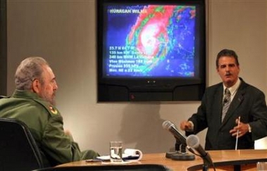 Cuban President Fidel Castro (L) and Cuba's chief weather forecaster Jose Rubiera talk about Hurricane Wilma during a live television program in Havana, October 23, 2005.