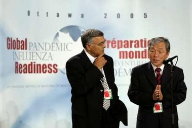 Canadian Health Minister Ujjal Dosanjh (L) listens to World Health Organization Director-General Lee Jong-wook speak on the first day of a two-day health conference in Ottawa October 24, 2005.