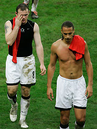 anchester United's Rooney and Ferdinand walk off the pitch after their Champions League group D soccer match loss against Lille at the Stade de France near Paris